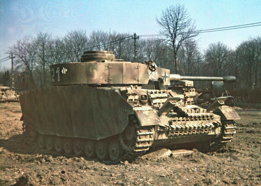 A Panzer IV of the Panzer-Lehr-Division in colour, standing on open ground with trees behind