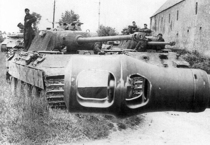 Two Panther tanks on a country road, a gun muzzle in the foreground