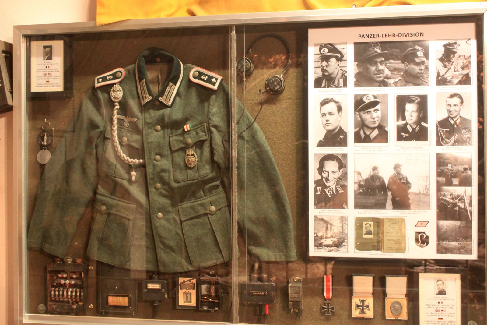 A museum display case with a Panzer Lehr Division uniform, medals and photographs