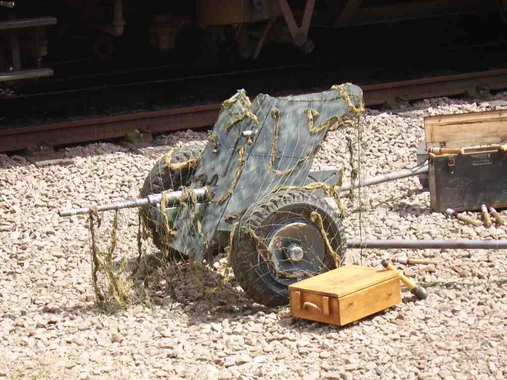 A camouflaged 3.7 cm PaK 36 anti-tank gun with ammunition boxes